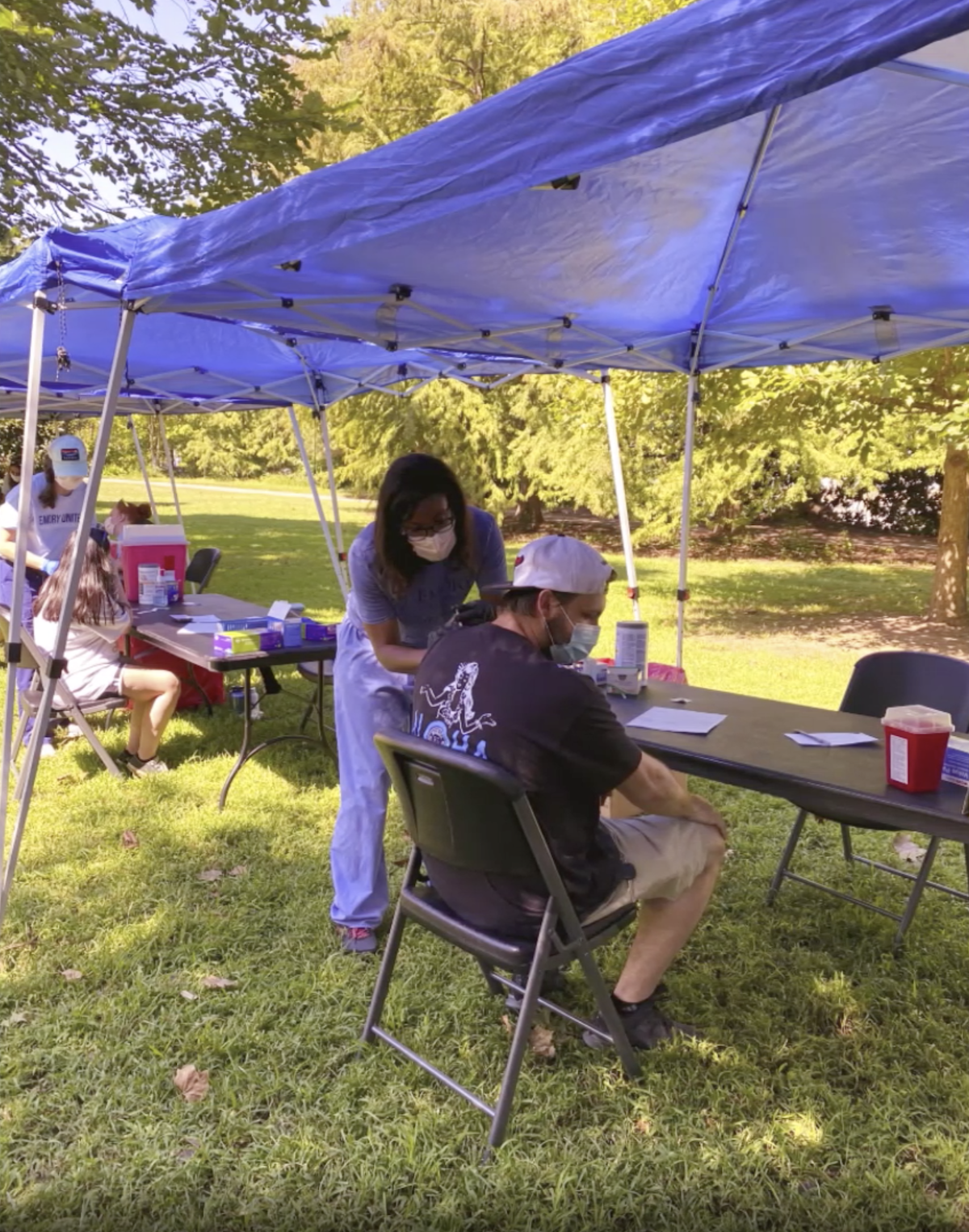 A volunteer administers a vaccine at an outdoor ORT event
